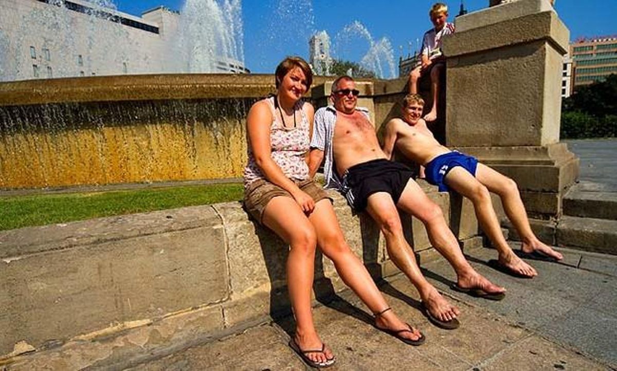 La plaça de Catalunya es converteix en un sauna per a aquesta família de turistes nòrdics.