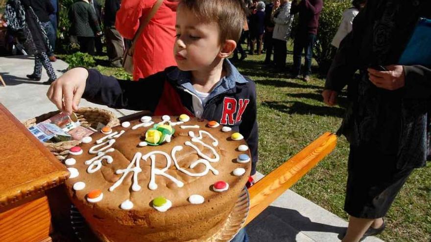 Un niño deposita dinero en la cesta situada junto a un dulce.