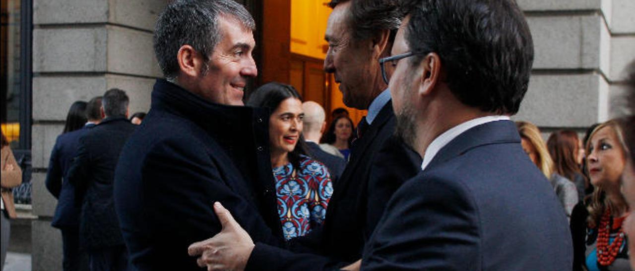 Fernando Clavijo saluda a Rafael Hernando ante la mirada de Asier Antona, ayer en la entrada del Congreso.