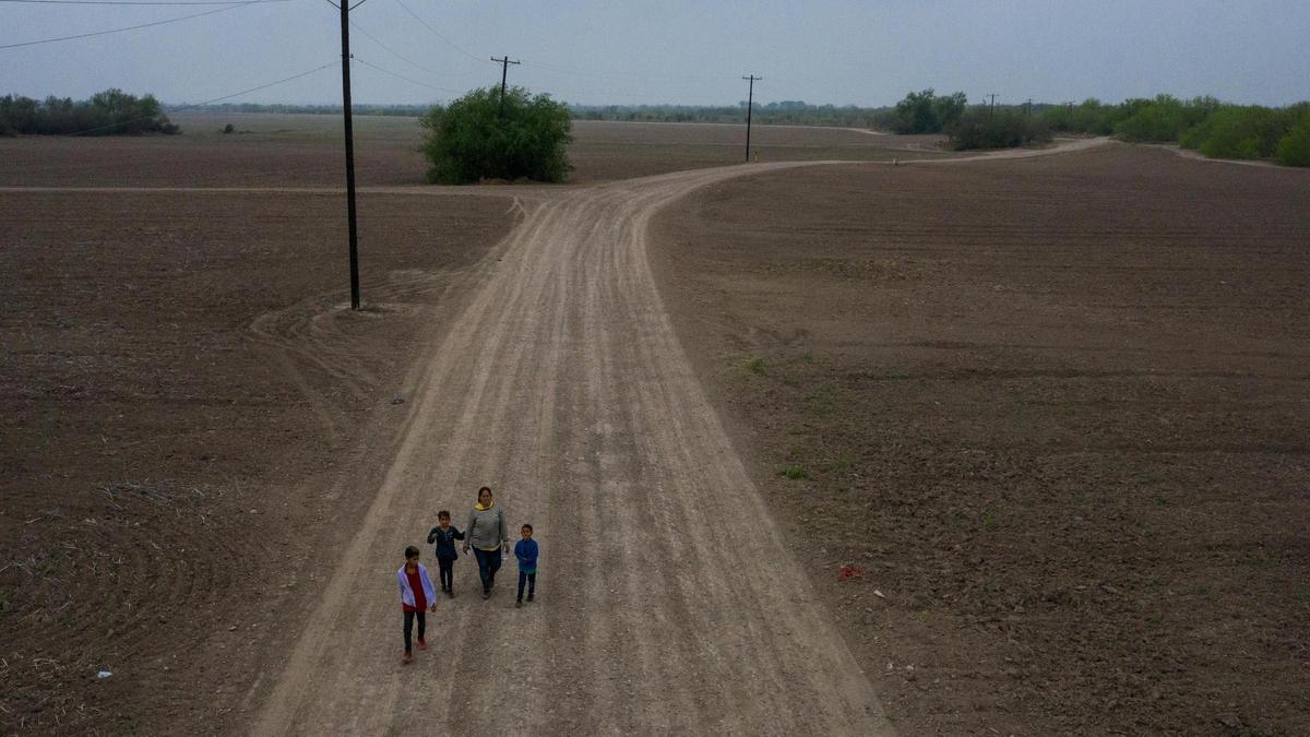 Migrantes caminan en la frontera de México y Estados Unidos.