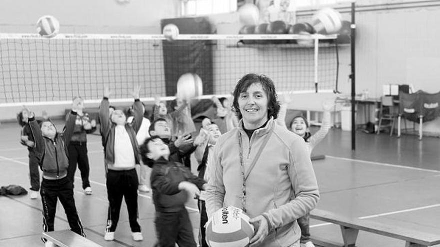 Ángeles García, con niños del equipo de voleibol del Colegio Cervantes de Gijón. / marcos león