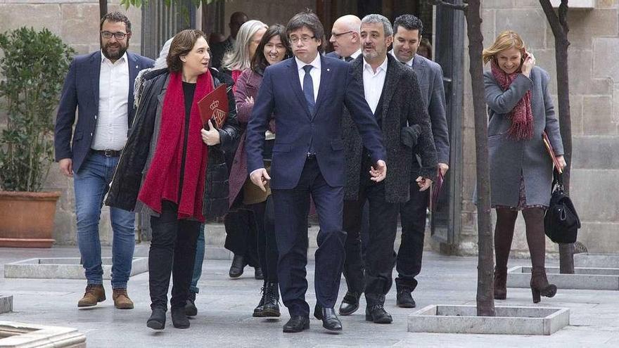 El presidente de la Generalitat, Carles Puigdemont (en el centro), y la alcaldesa de Barcelona, Ada Colau, en un acto ayer en Barcelona. // Efe