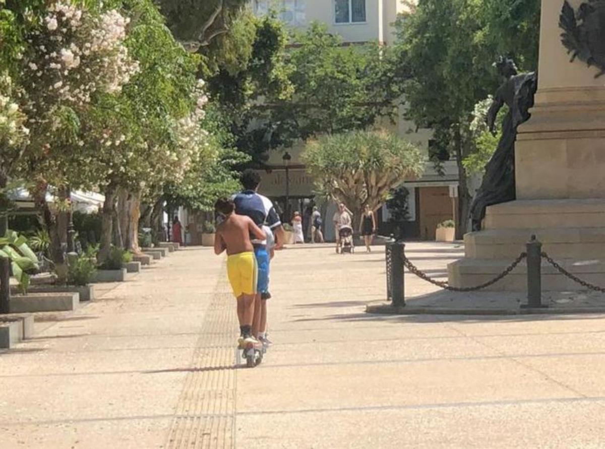 Tres chicos en un mismo patinete.