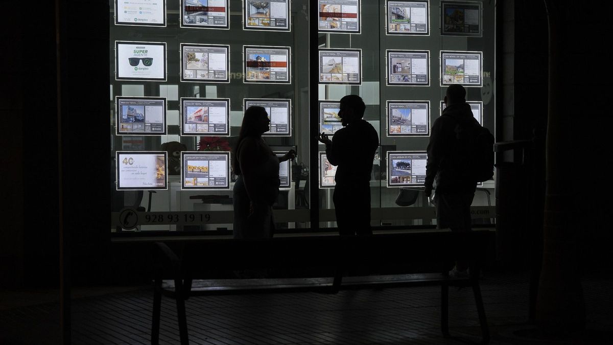 Varias personas miran ofertas inmobiliarias.