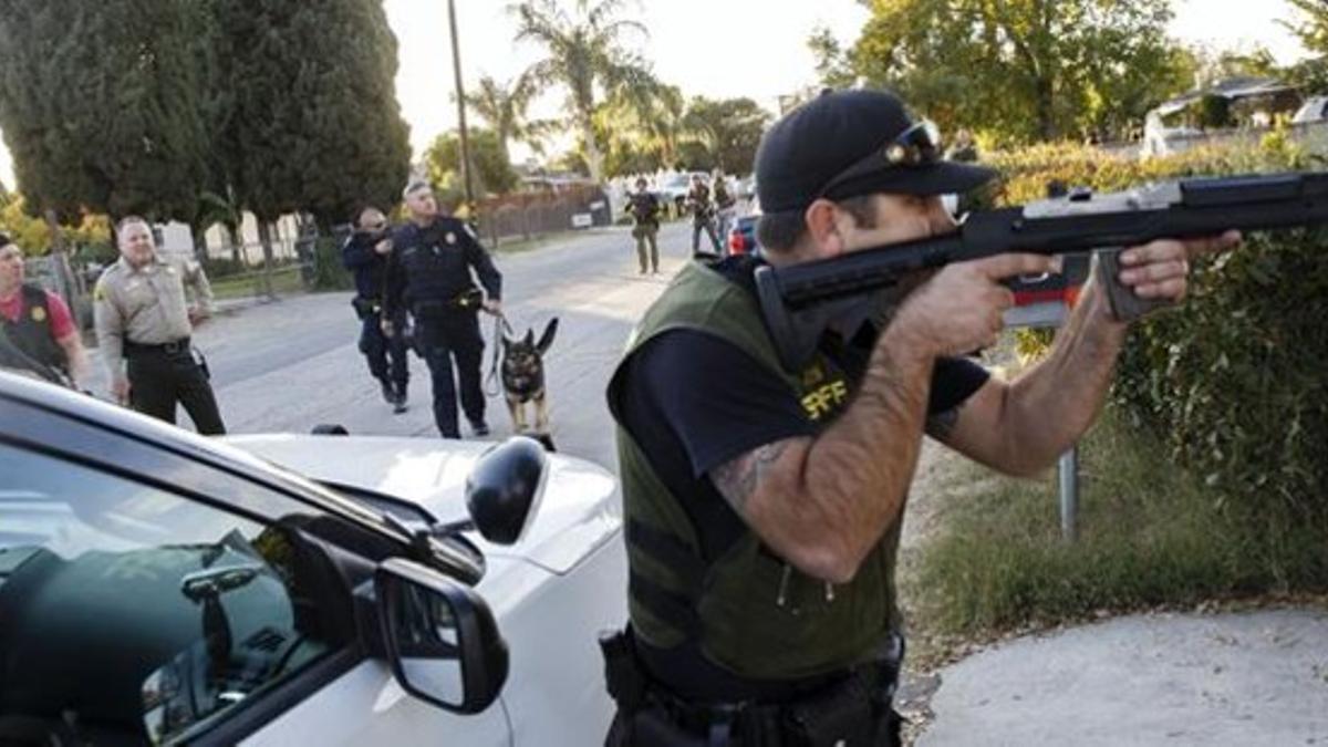 Un policía armado en la búsqueda de los sospechosos tras el tiroteo, en San Bernardino, este miércoles.