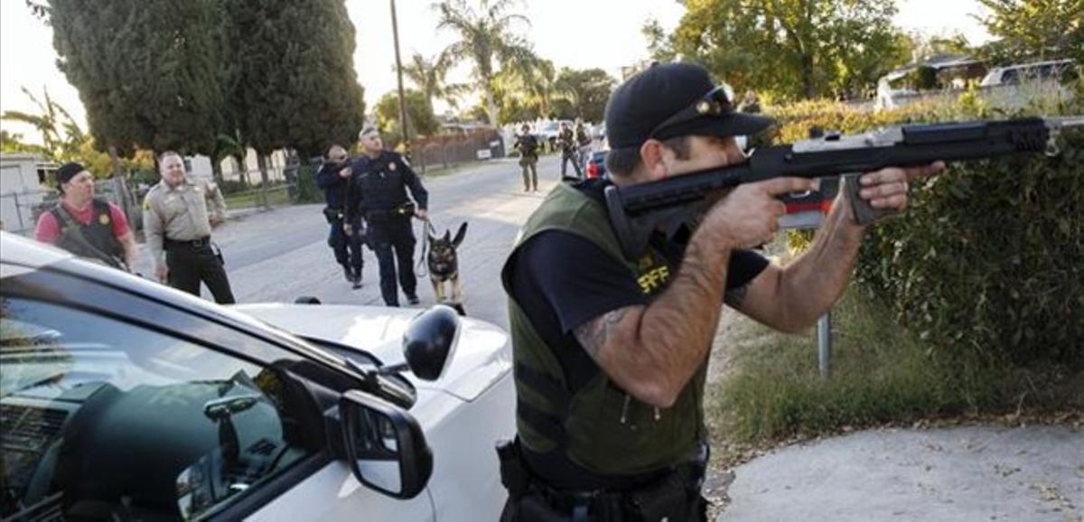 Un policia armat en la recerca dels sospitosos del tiroteig, a San Bernardino, aquest dimecres.