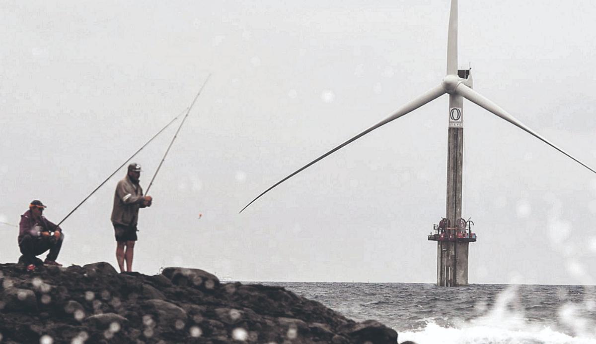 Pescadores, en primer término, y, al fondo, el aerogenerador que la ingeniería Esteyco prueba junto a la Plocan. | | JUAN CASTRO