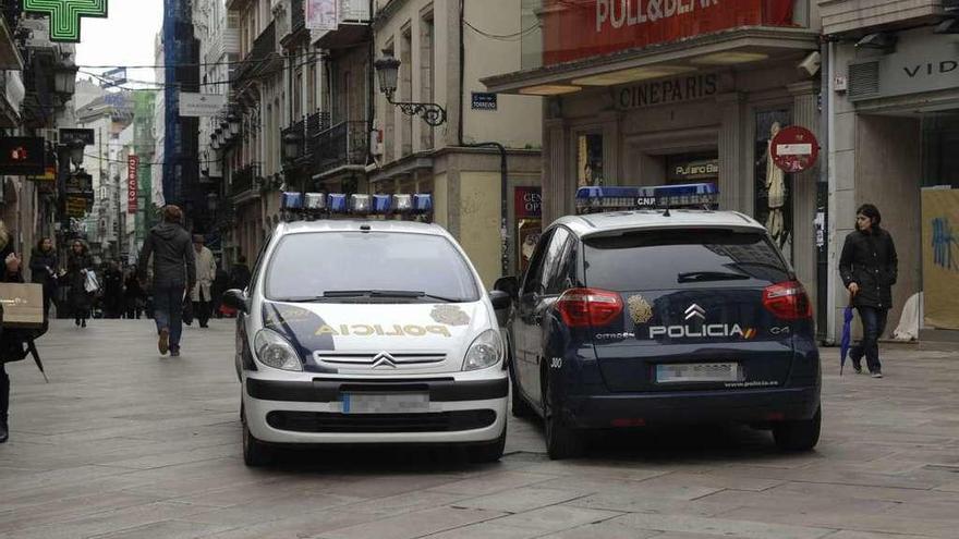 Dos coches de la Policía Nacional patrullan la calle Real, en 2011.