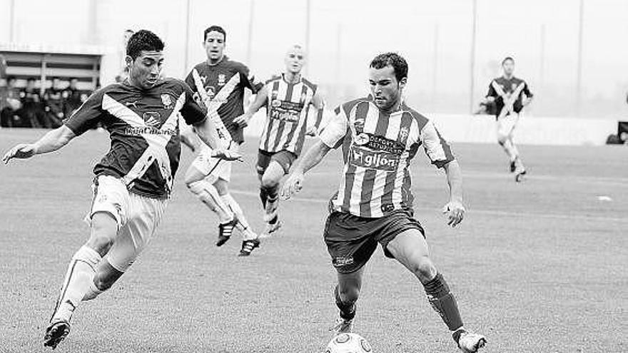 El rojiblanco Carlos controla el balón ante la presencia de un defensa del Tenerife B, en el partido de ida en Mareo.