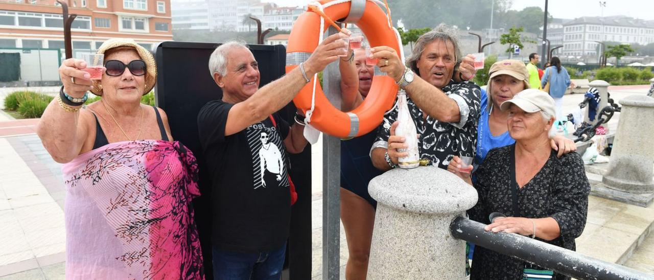 Bañistas de O Parrote brindan por la apertura de la zona de baño.   | // VÍCTOR ECHAVE