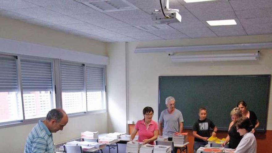 Varios padres organizan los libros en el inicio del nuevo curso.