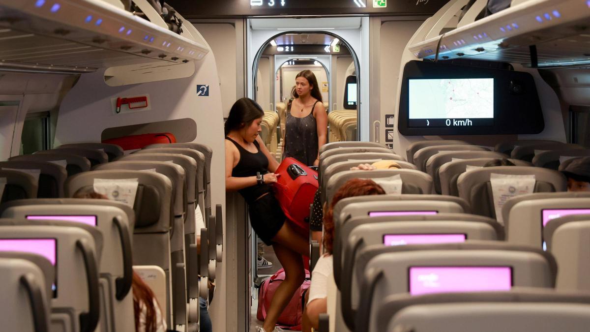 Jóvenes en un tren AVE en la estación de Vigo-Urzáiz este verano.