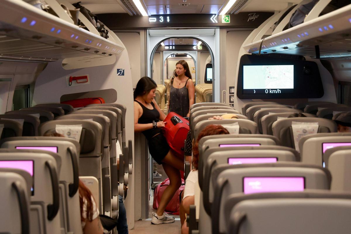 Jóvenes en un tren AVE en la estación de Vigo-Urzáiz este verano.