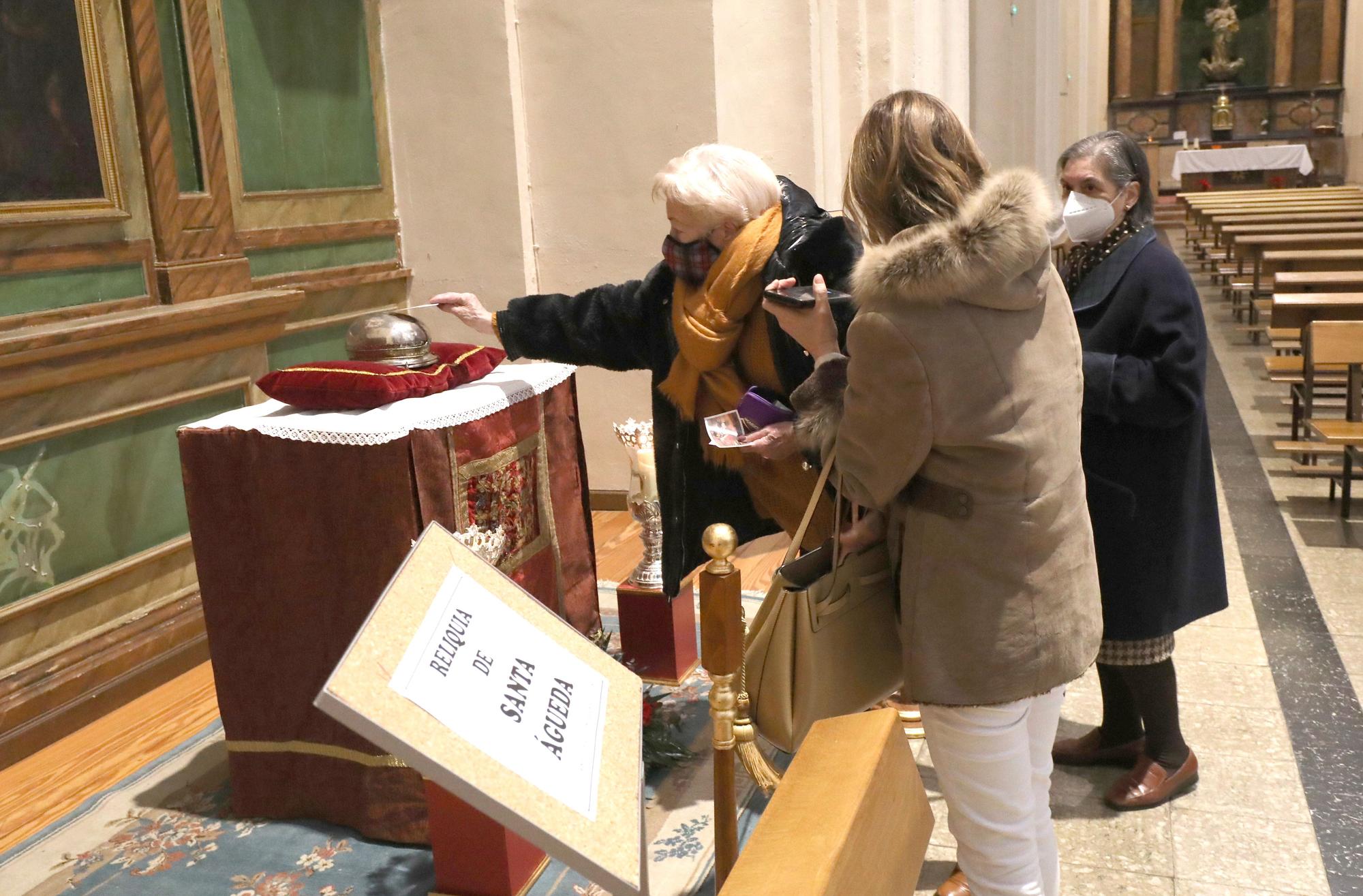 Una mujer frota la estampa con la reliquia