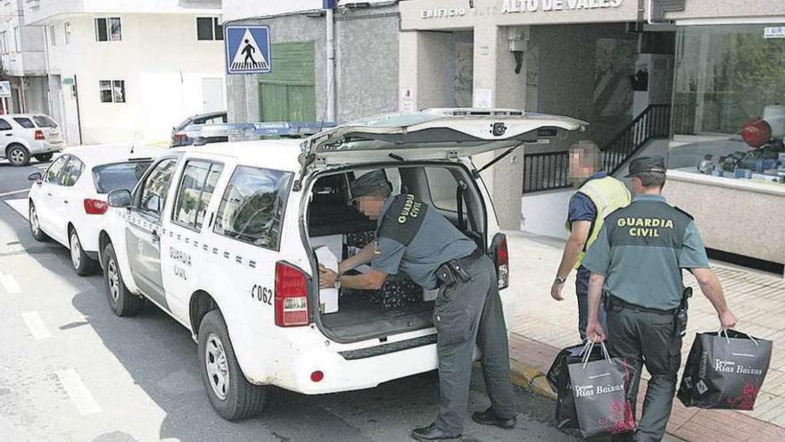 Agentes guardan en un vehículo diverso material del registro en la sede de Prosem. // Bernabé/Luismy