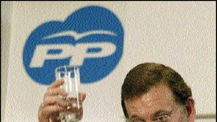 Rajoy sostiene un vaso de agua durante su intervención. / manuel lorenzo