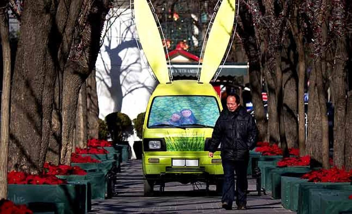Un home camina a prop d’una camioneta que ha estat decorada amb orelles de conill a l’estacionament d’un centre comercial a Pequín (Xina). Els xinesos fan les seves tradicionals compres per celebrar, el 3 de febrer vinent, l’arribada de l’any nou, el del Conill, segons el calendari lunar.