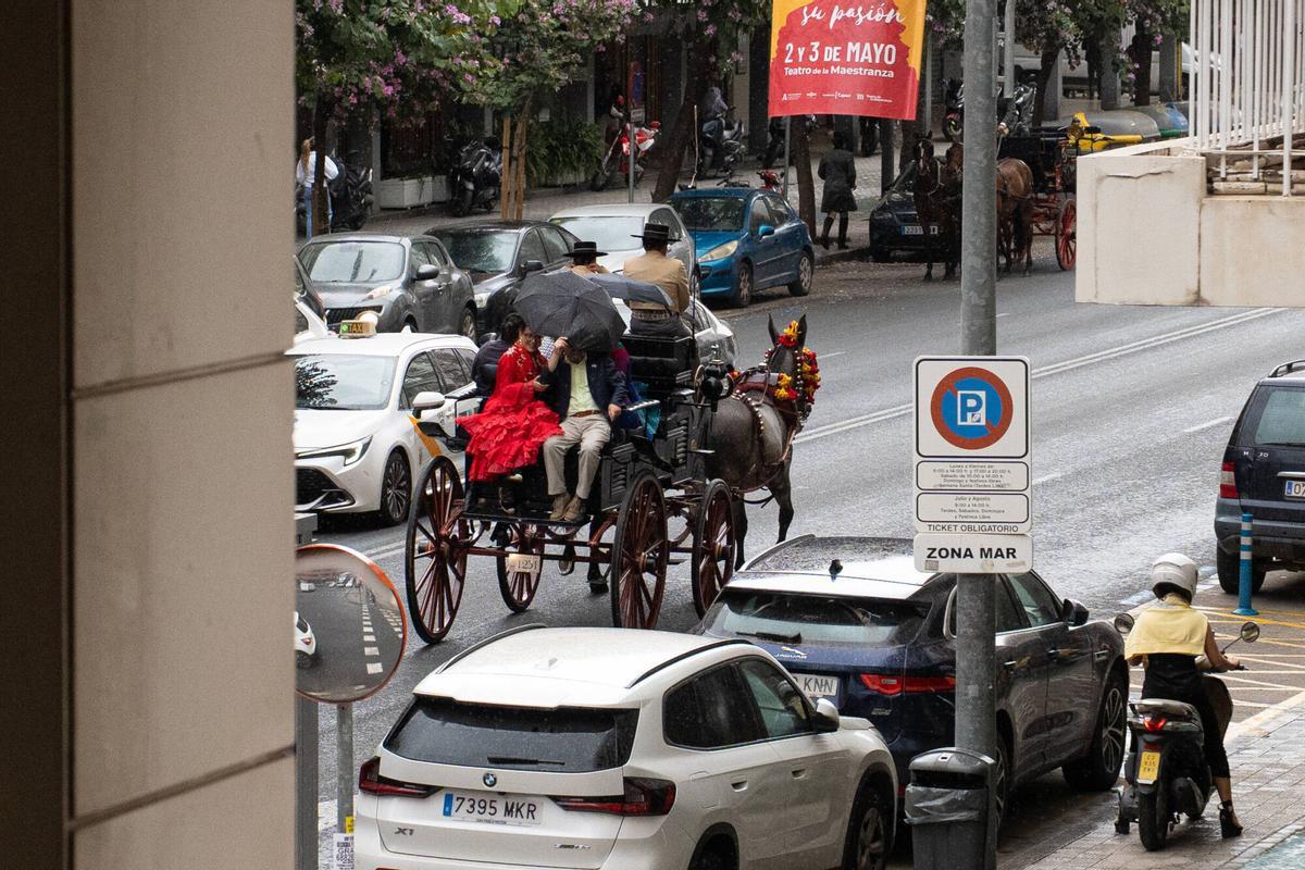 Personas con paraguas en coche de caballos