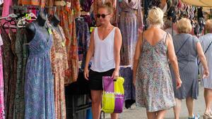 Turistas pasean y observan los puestos del mercadillo de la localidad grancanaria de Arguineguín. 