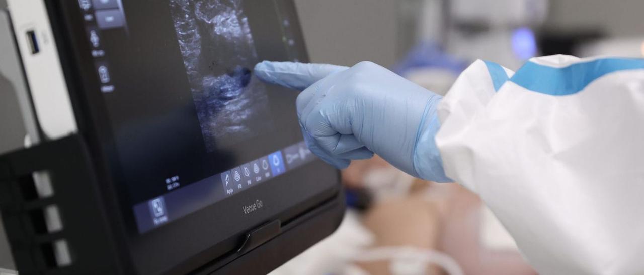 Una doctora le enseña la ecografía del feto a una mujer embarazada.