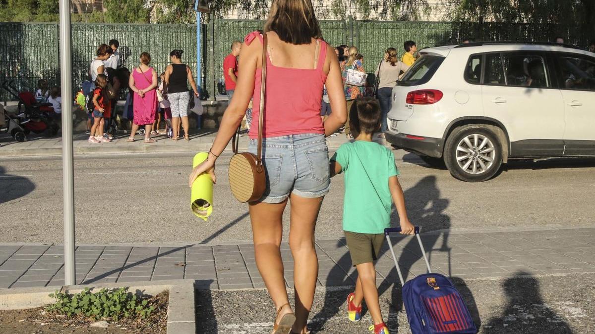 Una madre se dirige al colegio con su hijo