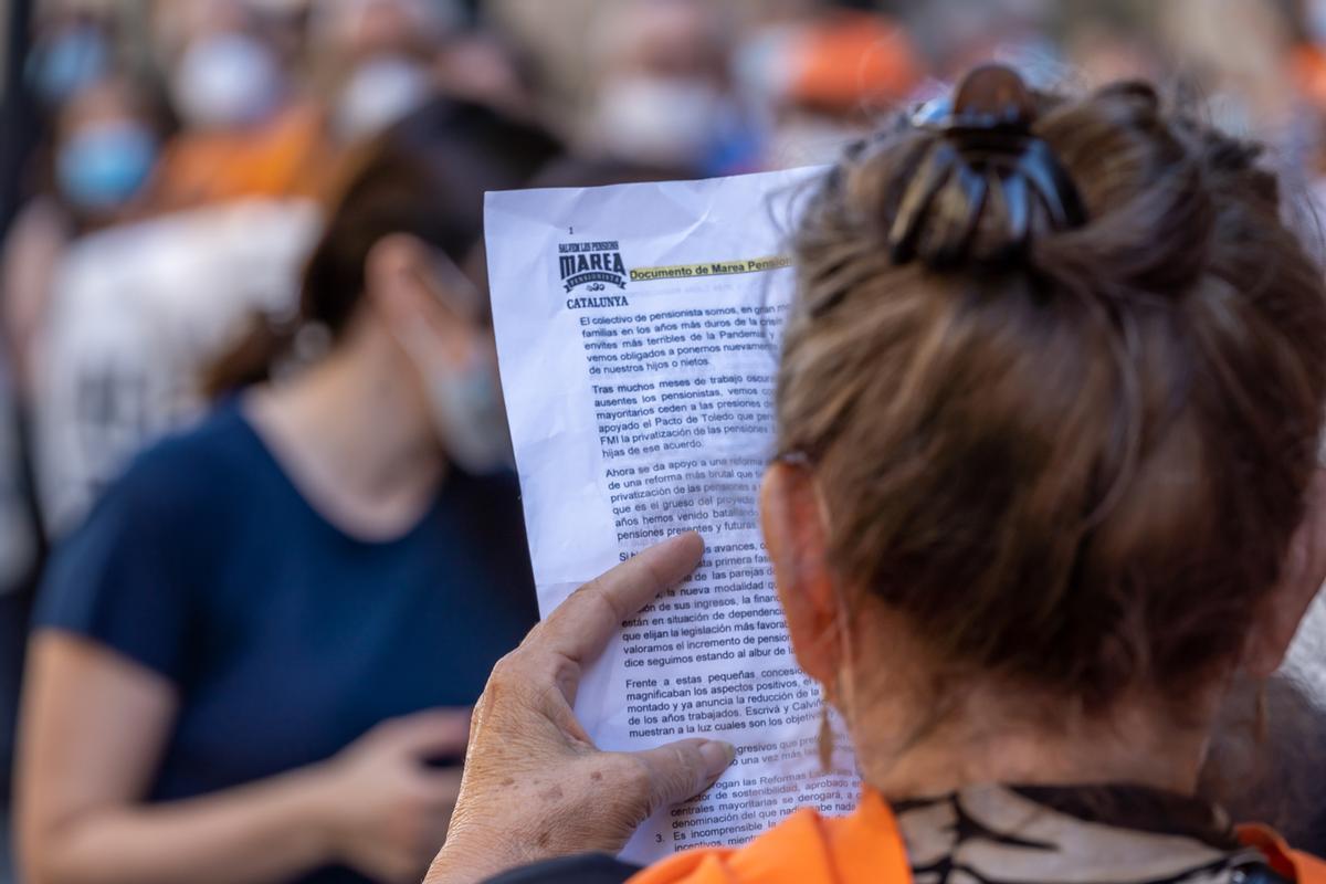 Una manifestante lee un manifiesto en una protesta para salvar las pensiones en Barceloba. Una manifestante lee un manifiesto en una protesta para salvar las pensiones en Barceloba.