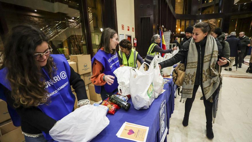 Voluntarios del Banco de Alimentos recogen bolsas con comida a la entrada del Auditorio.