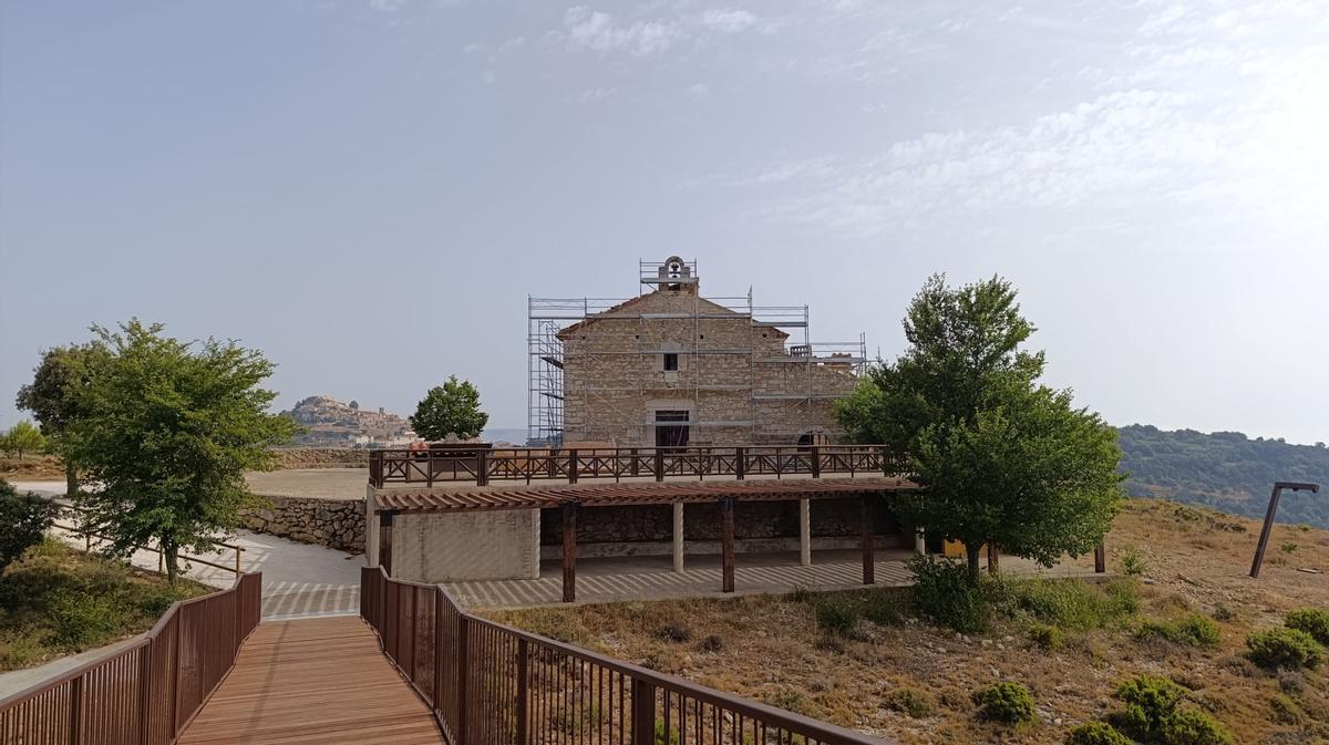 Imagen de la ermita tomada desde la pasarela panorámica, con el pueblo al fondo.