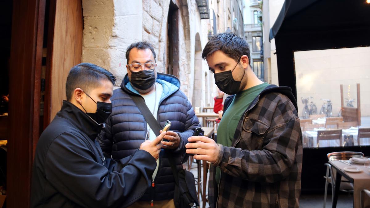 Dues persones ensenyant el certificat covid en un restaurant