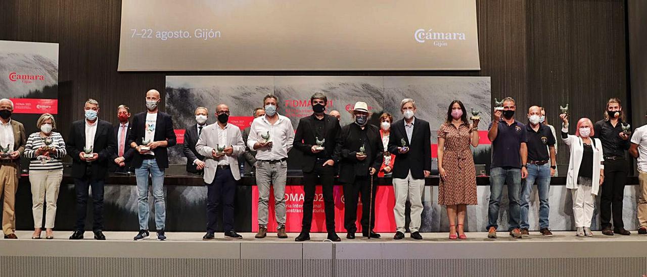 De izquierda a derecha, en primera fila, los premiados Ernesto García, Luis Parades, Josefina Méndez, Ángel Castaño, Pau Santirso, Eugenio Suárez, Xosé Antón González, Nando Agüero, Fernando Fueyo, Javier Barbón, Cristina Sánchez, Antonio Ortega, Elvira Fernández, Tarik Vázquez, Nel Cañedo, Mónica Gutiérrez y Jesús Gómez, ayer, en el salón de actos del recinto ferial Luis Adaro. | Juan Plaza