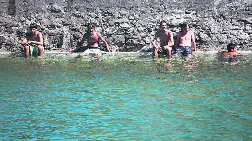 Un grupo de bañistas combate las altas temperaturas en el interior de la piscina de agua salada de Tapia de Casariego / ignacio pulido