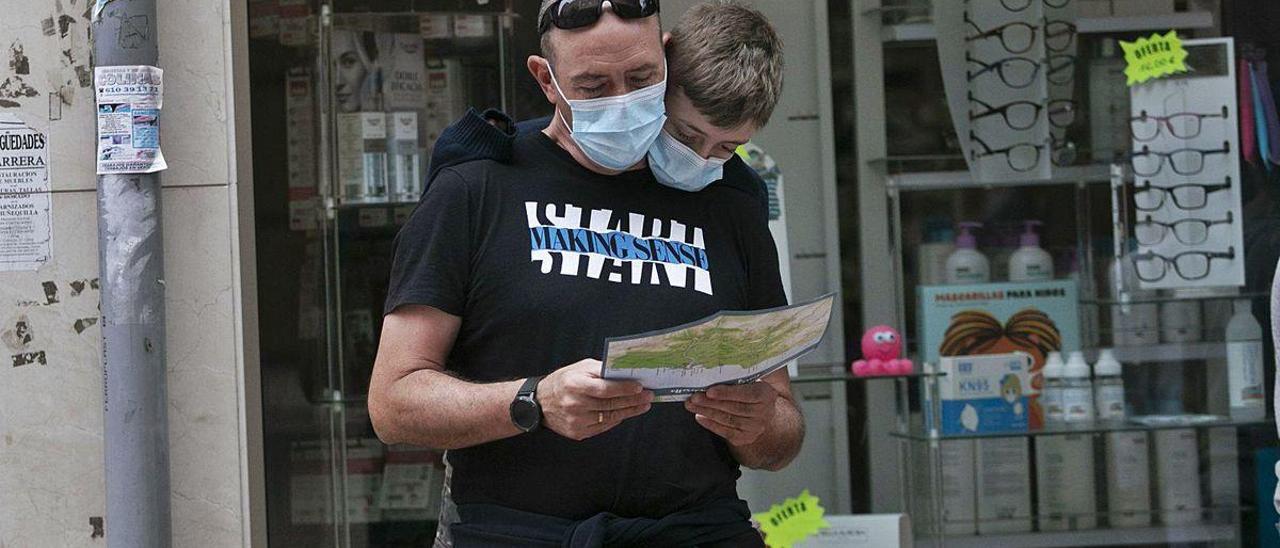 Unos turistas consultan un mapa en Ribadesella.