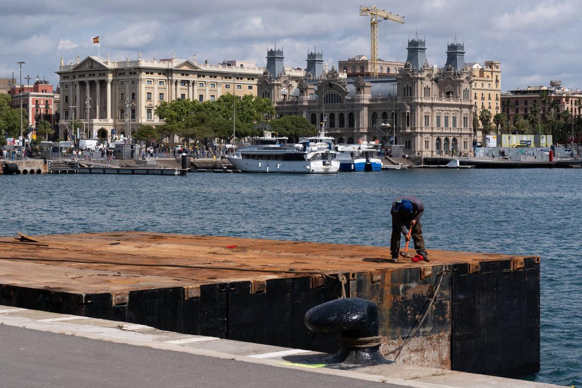Un operario trabajando en el montaje del escenario sobre el mar del Blaumarí Music Festival, este jueves en el Port Vell.