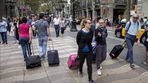 Turistas con maletas por las calles de Barcelona.