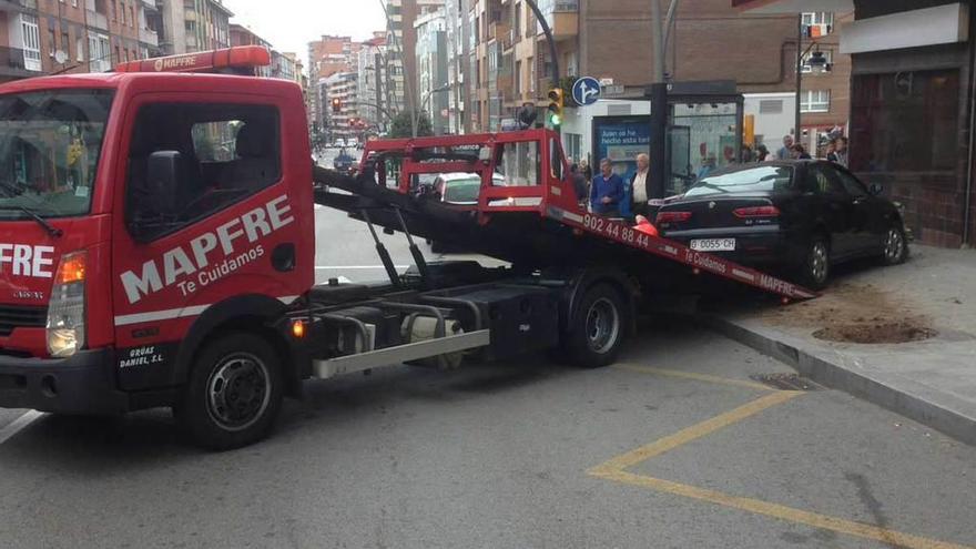 Un coche invade la acera y choca con un árbol