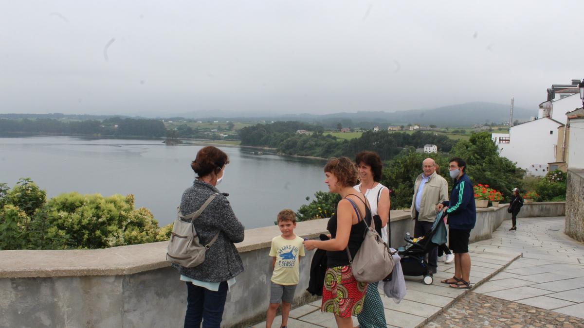 Visitantes observando las vistas a la ría del Eo desde el mirador de La Mirandilla. | T. Cascudo