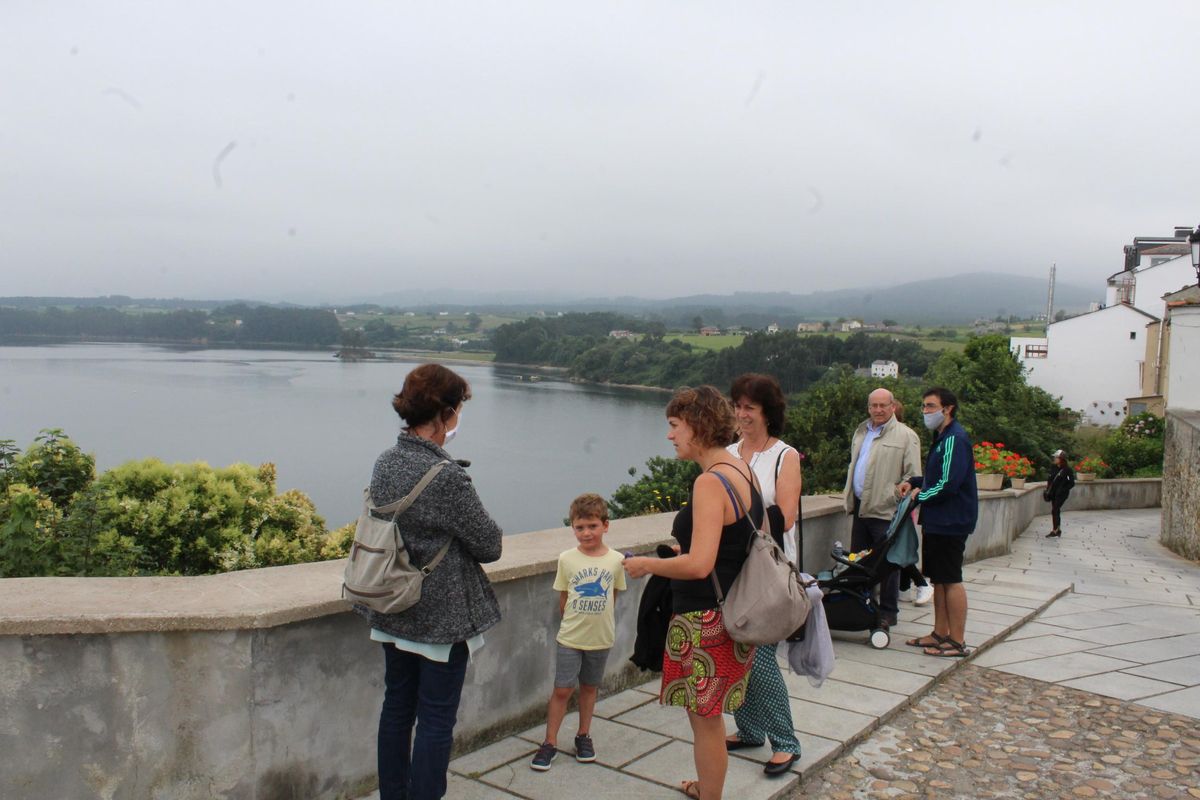 Visitantes observando las vistas a la ría del Eo desde el mirador de La Mirandilla. | T. Cascudo