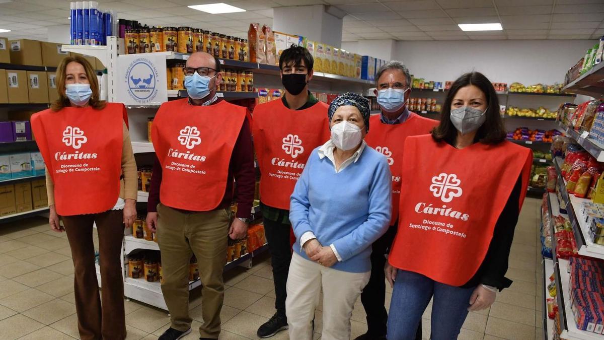 Pilar Farjas Abadía, directora de Cáritas Interparroquial de A Coruña (en el centro), junto a un grupo de voluntarios de la organización, esta semana, en el economato de la calle Bellavista.  | // VÍCTOR ECHAVE