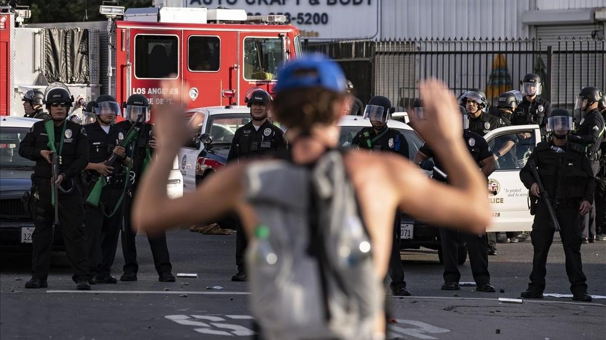 Un manifestante protesta ante varios policías, en Los Ángeles.