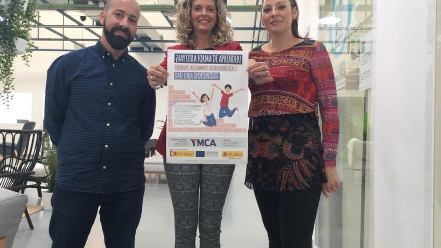Adrián González, Susana Corrales y Patricia Contreras, ayer, con el cartel del programa en la sede de YMCA Málaga.