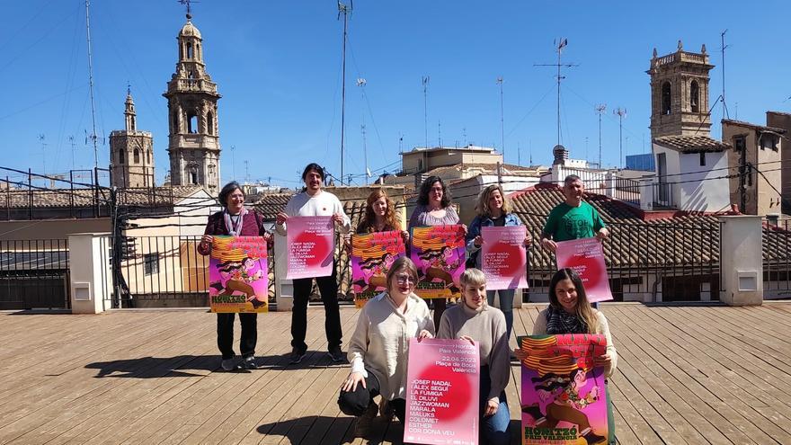 Organizadores y representantes del acto conmemorativo del 25  d'abril posan con el cartel en el ático del Octubre Centre de Cultura Contemporània