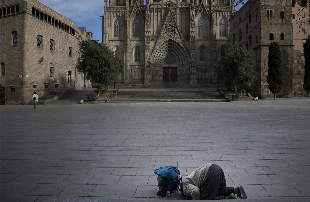 Un musulmán reza frente a la catedral de Barcelona.