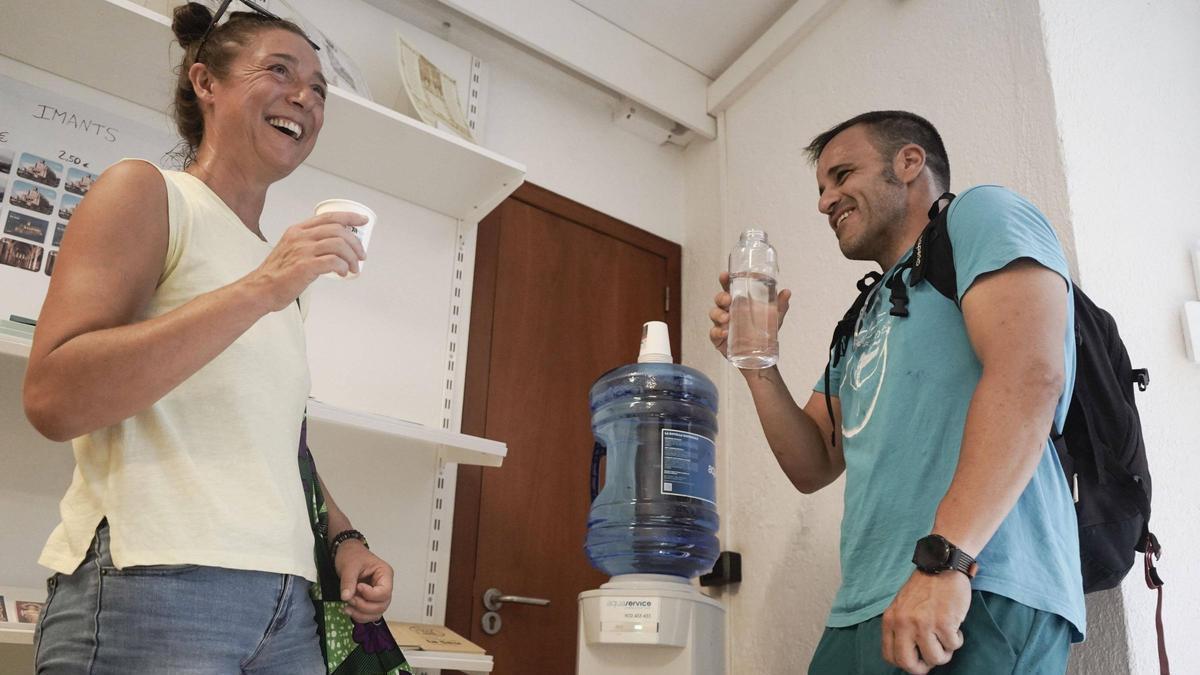 Dos turistes de Lleó s’hidraten al dispensador d’aigua que han posat aquest estiu a la recepció de la Seu