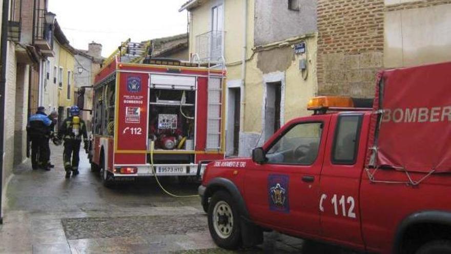 Dos bomberos y un agente de la Policía Local se preparan para acceder al interior de la vivienda. Foto