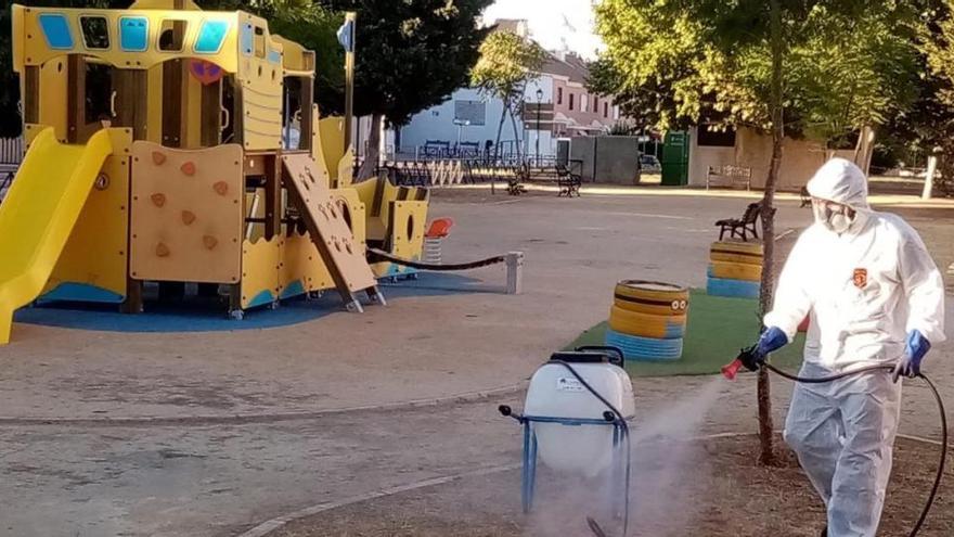 Un operario fumiga un parque infantil.