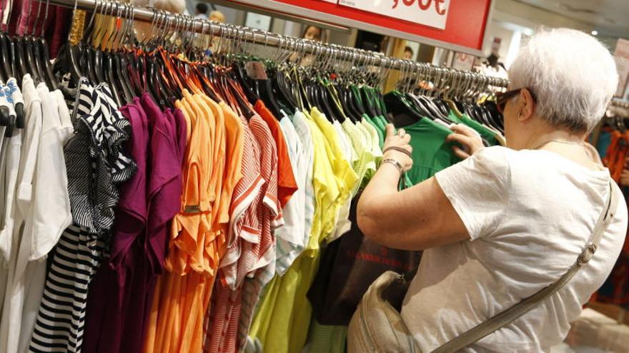 Una mujer mira ropa en unos grandes almacenes.