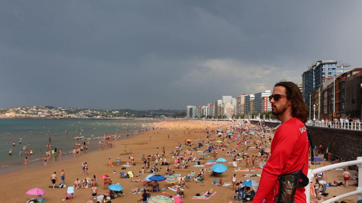 Un socorrista observa la playa de San Lorenzo desde el paseo del Muro.