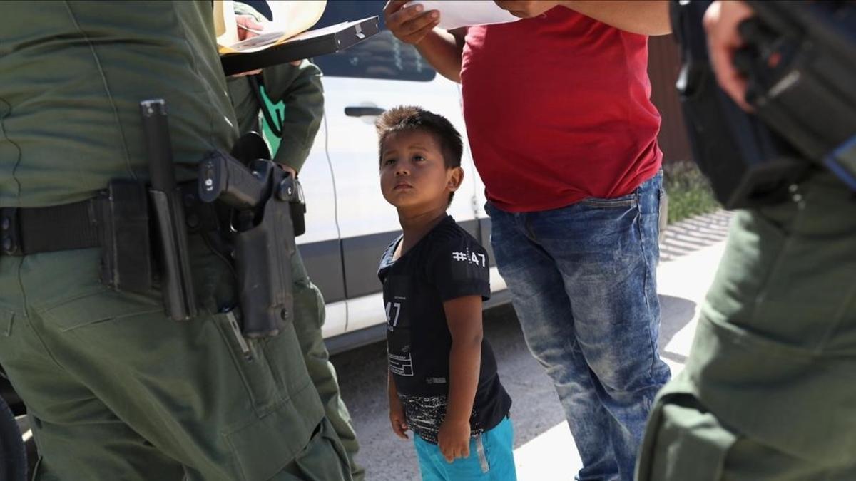 Un niño y sus padres, procedentes de Honduras, son retenidos por una patrulla policial cerca de la frontera de EEUU con México en Misión (Tejas), el 12 de junio pasado.