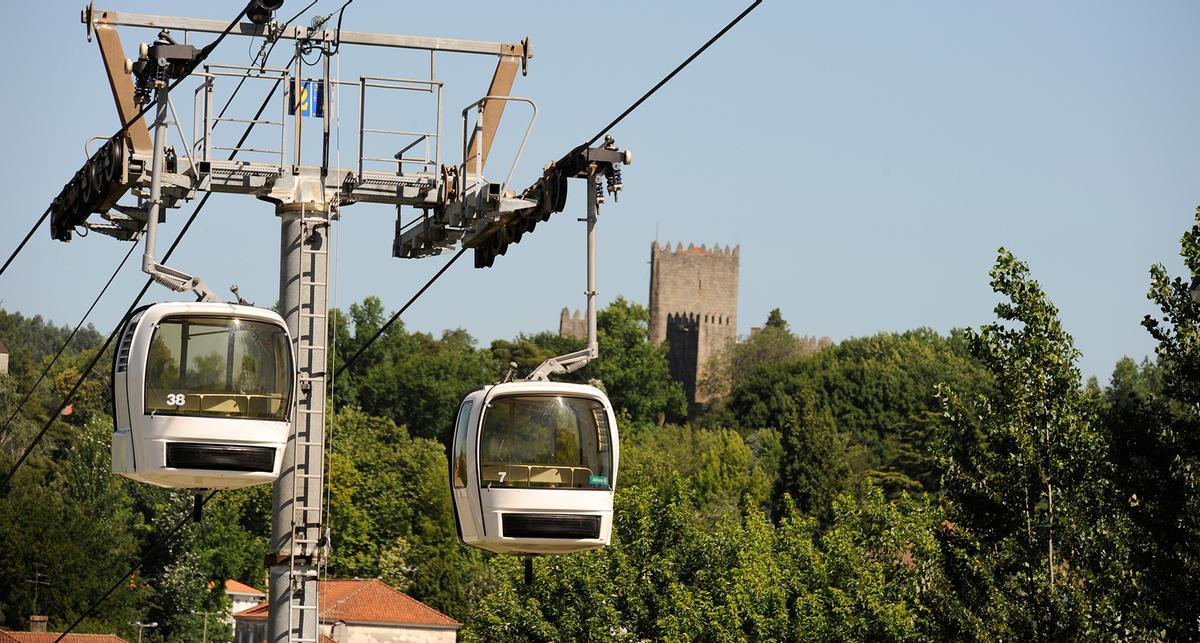 Dos cabinas del teleférico con el Castillo de Guimarães al fondo.