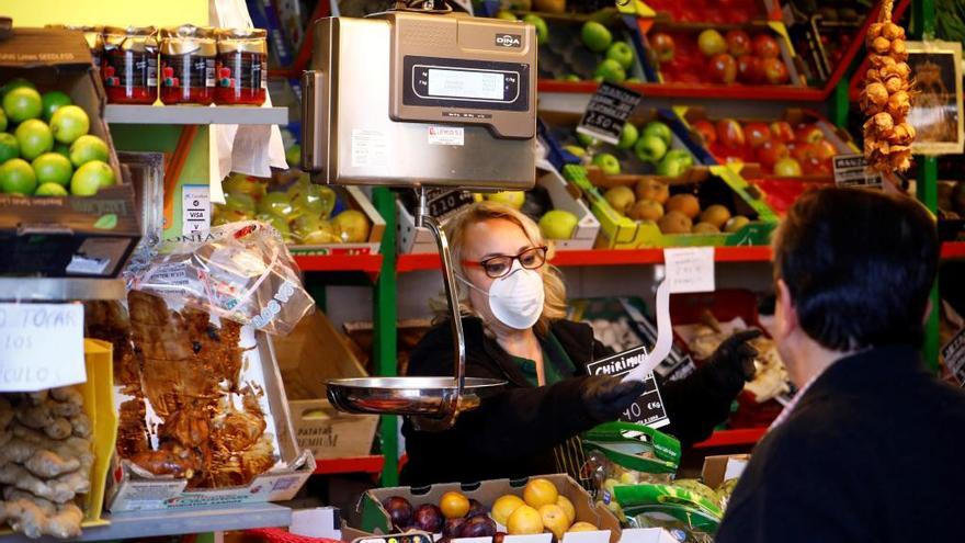 Una vendedora, protegida con mascarilla